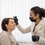 female client receiving expert eyebrow mapping before getting permanent cosmetic treatments