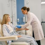 Professional doctor putting an IV drip to female patient intravenously in hospital