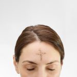 Woman with cross made from ash on forehead. Ash wednesday concept