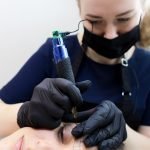 permanent-makeup-artist-leans-client-performs-eyebrow-tattoo_320071-769